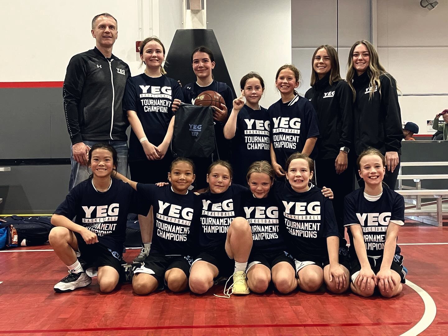 YEG BASKETBALL girls team celebrating a Classic championship with their coaches